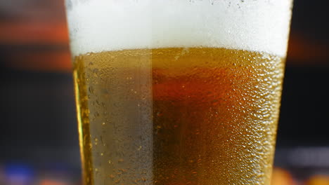 Close-up-slow-motion:-cold-Beer-in-a-glass-large-drops-and-bubbles-in-the-beer